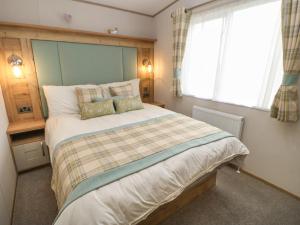 Un dormitorio con una cama grande y una ventana en 10 Cheviot View, en Berwick-Upon-Tweed
