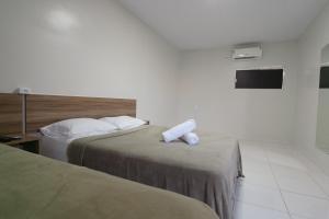 a hotel room with two beds and a tv at Hotel Verde Mares in Macapá