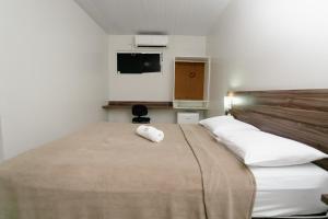 ein Schlafzimmer mit einem Bett und zwei weißen Kissen in der Unterkunft Hotel Verde Mares in Macapá