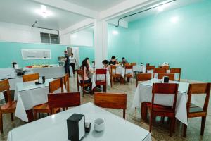 Eine Gruppe von Menschen sitzt an Tischen in einem Restaurant in der Unterkunft Hotel Verde Mares in Macapá