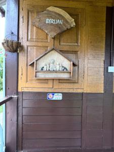 una porta marrone del garage con un cartello sopra di BUKIT LIMAU REST HOUSE a Taiping