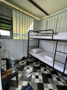 Cette chambre comprend 2 lits superposés et un sol en damier. dans l'établissement BUKIT LIMAU REST HOUSE, à Taiping