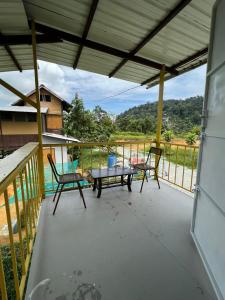 d'une terrasse avec 2 chaises et une table sur un balcon. dans l'établissement BUKIT LIMAU REST HOUSE, à Taiping