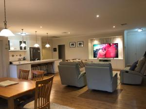 sala de estar con sofá, mesa y cocina en Belle B&B Country Retreat, en Penwortham