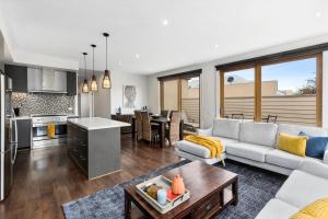 a living room and kitchen with a couch and a table at The SCOOP in Queenscliff