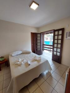 ein Schlafzimmer mit einem Bett mit Handtüchern darauf in der Unterkunft Pousada Don Antonio Praia - 50 metros da Praia! in Garopaba