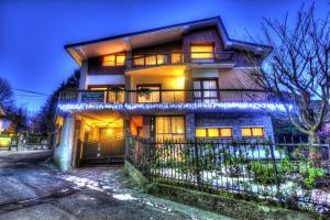 une maison avec des lumières devant elle la nuit dans l'établissement B&B dei Laghi, à Magreglio