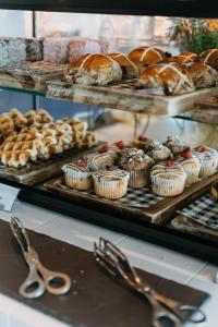 a display case with various pastries and muffins and scissors at Pullman Magenta Shores Resort in The Entrance