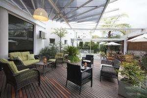 a patio with couches and chairs and tables at Los Tilos Hotel y Spa by CPH in Villa Carlos Paz
