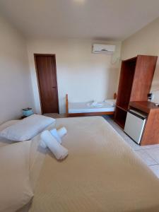 1 Schlafzimmer mit 2 Betten und Handtüchern auf dem Boden in der Unterkunft Pousada Don Antonio Praia - 50 metros da Praia! in Garopaba