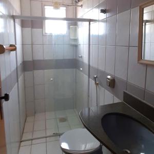 ein Bad mit einem WC und einem Waschbecken in der Unterkunft Apartamento super arejado na Praia do Morro in Guarapari