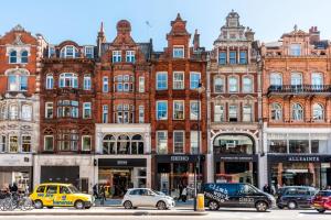 a large brick building with cars parked in front of it at Ennishmore Mews Apartment in London