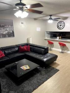 a living room with a black leather couch and a table at Modern 2 Bedroom Townhome Minutes from the Beach!! in Fort Walton Beach