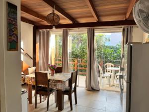 a kitchen and dining room with a table and a window at Flat Casagrande in Morro de São Paulo