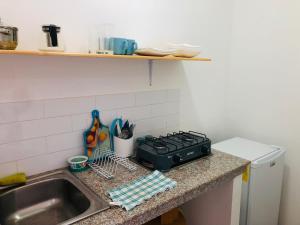 um balcão de cozinha com um lavatório e um fogão em EL JARDIN OLON SUITES em Olón
