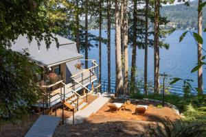 una piccola casa con una scala vicino all'acqua di Casa Las Nubes NEW! Whatcom Lakefront Cabin/HotTub a Bellingham