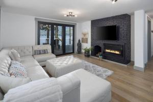 un soggiorno con un divano bianco e un camino di Casa Las Nubes NEW! Whatcom Lakefront Cabin/HotTub a Bellingham
