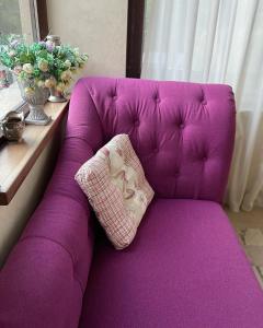 - un canapé violet avec un oreiller dans l'établissement Casa Beatrice, à Grăjdana