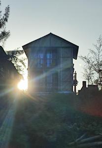 una casa con il sole che tramonta dietro di essa di Chivarin Resorts a Malwan