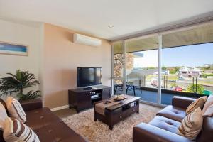 Una sala de estar con un sofá y un televisor. en Resort Penthouse 301, en Torquay