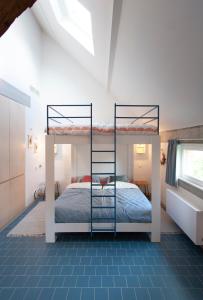 een slaapkamer met 2 stapelbedden op een zolder bij Origineel gerenoveerde schuur nabij Antwerpen in Zoersel