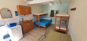 mały pokój z 2 łóżkami piętrowymi i stołem w obiekcie Golden Bay Holiday Park w mieście Onekaka