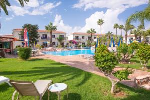 a resort with a swimming pool and palm trees at Loutsiana Deluxe Apts in Ayia Napa