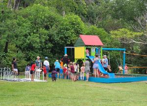 un gruppo di bambini gioca in un parco giochi di Golden Bay Holiday Park a Onekaka