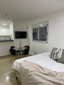 a bedroom with a bed and a table and a tv at Hermoso monoambiente a estrenar pleno centro Santiago del Estero Dpto Azul in Santiago del Estero