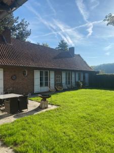 una casa con cortile dotato di tavolo e sedie di Le Clos de Bénédicte a Bondues