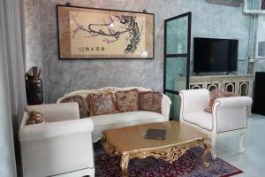 uma sala de estar com um sofá e duas cadeiras e uma mesa em Vathanagul Resort em Chiang Rai