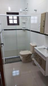 a bathroom with a toilet and a sink at Casa Centro com Piscina in Ubatuba +20 photos