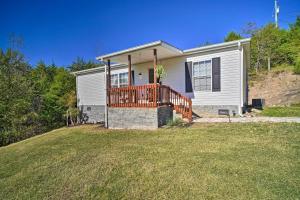 Casa blanca pequeña con terraza de madera en un patio en Pet-Friendly Midway Abode with Yard and Fire Pit!, 