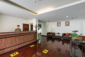 two people standing at the reception counter in a lobby at Phunawa Resort Phuket Karon Beach - SHA Plus in Karon Beach