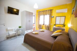 1 dormitorio con 1 cama grande y paredes amarillas en B&B Pepito, en Cefalú