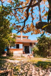 a house in the middle of a yard with trees at Paikea Hostel Praia do Rosa in Praia do Rosa