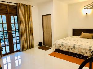 a bedroom with a bed and a large window at Hotel mango tree nearest Adam's peak in Adams Peak