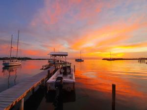 un bateau amarré à un quai avec un coucher de soleil dans l'établissement Santuarios del Mar, à Bocas del Toro