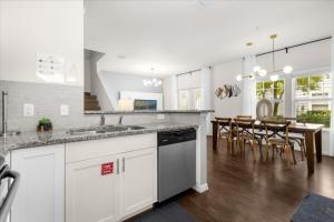 a kitchen with white cabinets and a dining room with a table at 4 Bedrooms 3 Bathrooms Lucaya Village 21-101 in Orlando