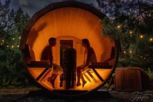 a man and a woman sitting inside of a barrel at Dziupla House in Czarna