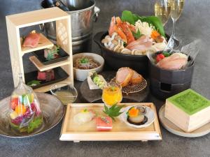 - une table avec des assiettes de nourriture et des verres de vin dans l'établissement OWL RESORT ARIFUKU ONSEN, à Gotsu