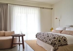 a bedroom with a bed and a couch and a window at Lancemore Milawa in Milawa