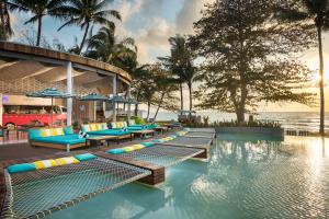 Avani Chaweng Samui Hotel & Beach Club في شاطئ تشاوينغ: مسبح المنتجع مع كراسي الجلوس والمحيط