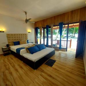 a bedroom with a large bed with blue pillows at Lemon Grass Resort & Spa in Havelock Island
