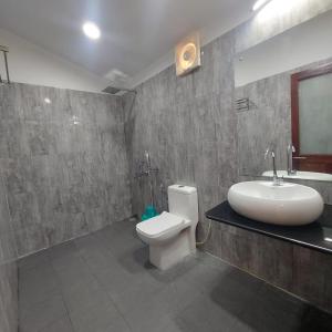 a bathroom with a white toilet and a sink at Lemon Grass Resort & Spa in Havelock Island