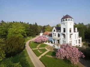 ein großes weißes Haus mit einem Turm darüber in der Unterkunft de Harmonie in Molenhoek