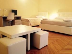 een kamer met 2 bedden, een tafel en een bureau bij Alle Torri in Bologna