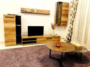 Luxury apartment في أراد: غرفة معيشة مع تلفزيون وطاولة