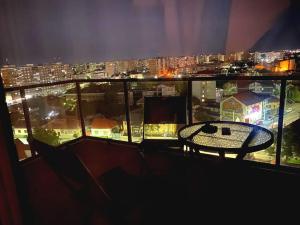 a table on a balcony with a view of a city at Luxury apartment in Arad