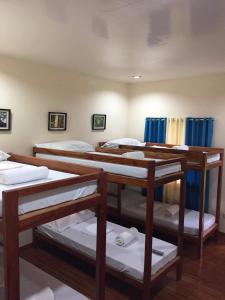 Balbagon的住宿－Camguin Lanzones Resort，一间设有四张双层床和蓝色窗帘的房间